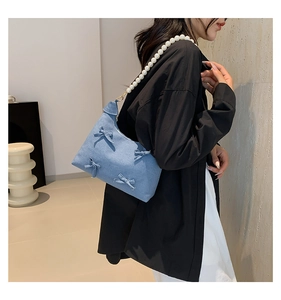 Blue denim shoulder bag featuring sweet bow details and a large white pearl bead strap