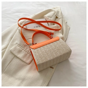 Detail of summer straw crossbody bag with orange leather flap on casual blazer