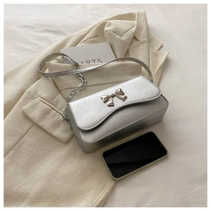 Detail of silver metallic leather handbag with a delicate butterfly metal buckle