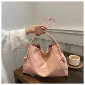 Dettaglio della borsa tote in morbida pelle rosa con scritte 3D a rilievo e nodi decorativi