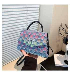 Detail der karierten Denim-Handtasche mit silberner Schleife und Ledergriffen