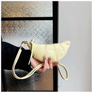 Detail of cheese yellow crescent horn bag with pleated design and knot shoulder strap