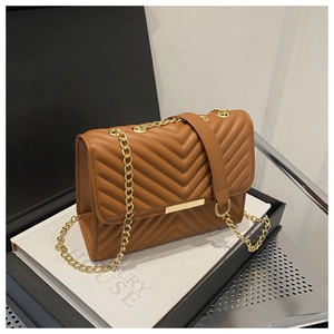 Close-up of brown chevron quilted bag with golden chain strap and metal bar detail