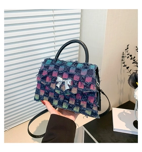 Detailansicht der Karo-Jean-Handtasche mit Fransenkante und silberner Schleifenschnalle