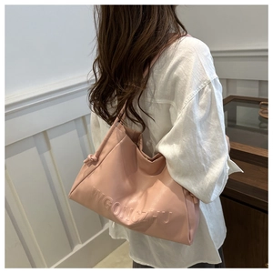 Dettaglio borsa tote in morbida pelle rosa con goffratura WGONCZHU e manico annodato