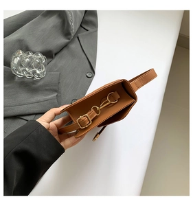 Detail of the caramel brown crocodile texture bag with premium gold metallic buckle
