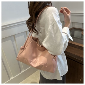 Dettaglio del logo goffrato WGONGZHU e della texture in ecopelle rosa sulla borsa tote