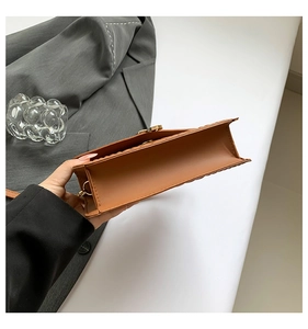 Detail view of the caramel crocodile pattern handbag side profile with gold hardware