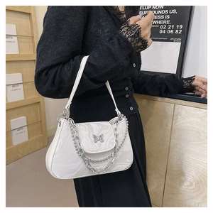 Close-up of marble texture underarm bag with silver butterfly clasp and metal chain