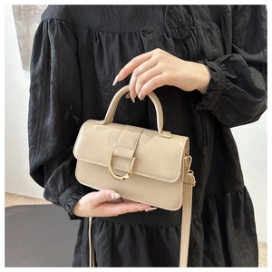 Dettaglio borsa beige con fibbia a U dorata e trama liscia in pelle sintetica PU