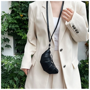Close-up of black quilted leather croissant pouch with adjustable neck strap and metal clasp