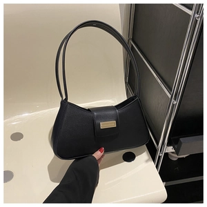 Detail der minimalistischen schwarzen Baguette-Tasche mit Textur und goldener Schnalle