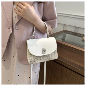 Detail of woven straw handbag featuring white leather flap and silver twist lock closure