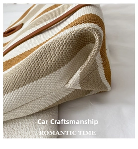 Detailed close-up showing the bottom seam and woven texture of the striped canvas tote bag