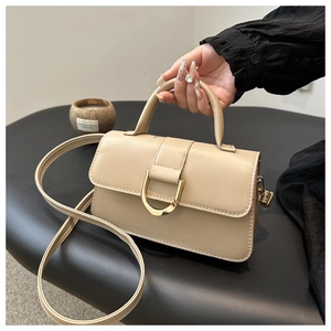 Dettaglio della borsa beige in ecopelle con fibbia a ferro di cavallo dorata e tracolla