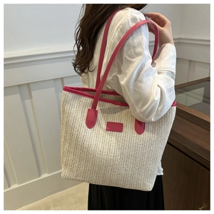 Detail of hand-woven straw tote with vibrant magenta leather trim and slim shoulder straps