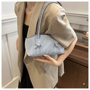 Détail du sac à bandoulière bleu clair avec texture marbrée et sangle à nœud décoratif