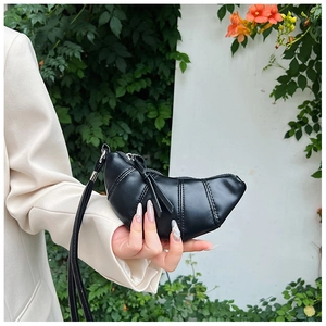 Detailed view of black matte leather croissant bag with longitudinal quilting and silver hardware