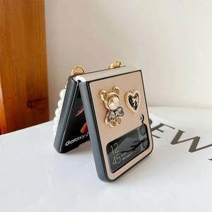 Detail of luxury Z Flip phone case featuring rhinestone bear and pearl strap handle