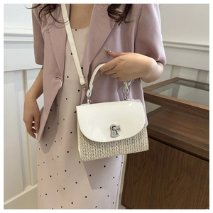 Straw crossbody bag with white leather flap and silver keyhole lock shown on model