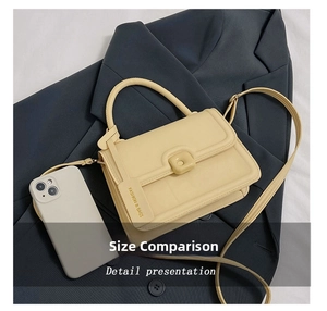 Detail view of a beige minimalist crossbody bag with a square buckle and fashion tag