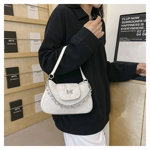 Détail du sac à motif marbre blanc cassé avec fermoir papillon et chaîne en métal