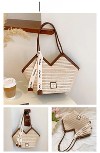 Detail of a large straw tote bag featuring white weaving and brown leather V-shaped trim