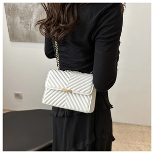 White chevron quilted bag with gold chain strap shown on model for size perspective