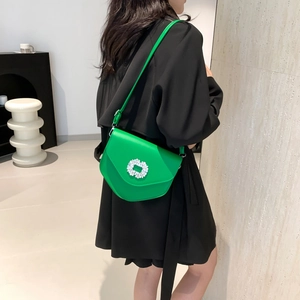 Sacoche selle verte en cuir avec boucle en strass porté par un mannequin