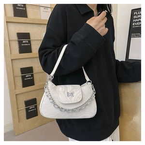Détail d'un sac porté épaule marbré avec boucle papillon argentée et bandoulière chaîne