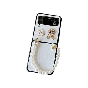 White Z Flip 6 case featuring cross pattern, pearl strap, and sparkly bear charm decor