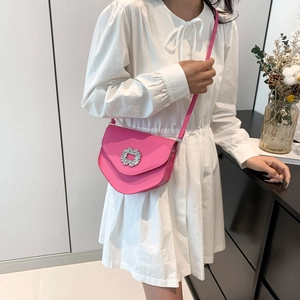 Sac bandoulière magenta avec boucle en cristal brillant sur une robe blanche