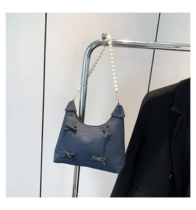 Blue denim underarm bag featuring fabric bows and elegant white pearl shoulder strap