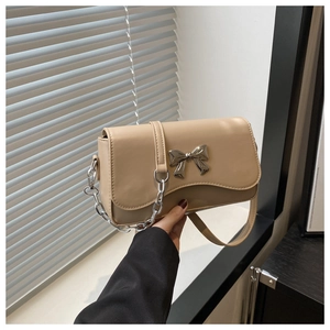 Detail of khaki leather bag featuring silver butterfly clasp and wavy flap design