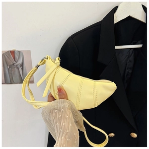 Detail of yellow crescent croissant bag showing stitching and vegan leather texture