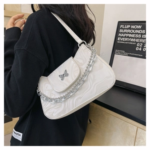 Détail du sac à bandoulière motif marbre blanc avec papillon argenté et chaîne métal