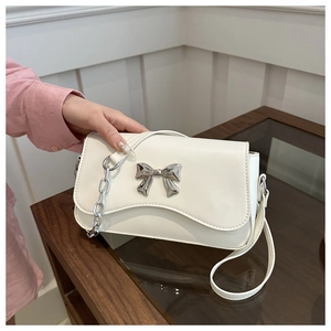 Detail of cream white PU leather crossbody bag with silver bow and chunky chain handle