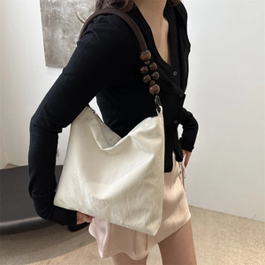 Minimalist cream shoulder bag with brown braided strap and wooden bead accents