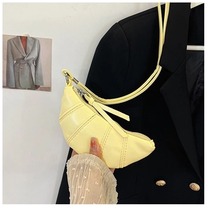 Close-up of a pale yellow mini croissant bag with pleated PU leather detail
