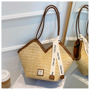 Detail of straw tote bag with brown leather straps and Sport Fashion leather patch