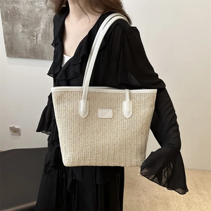 Straw tote bag with white leather straps shown on a model for beach or summer style