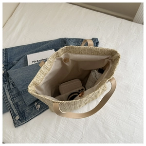Top view of large straw tote bag interior showing spacious storage and magnetic closure