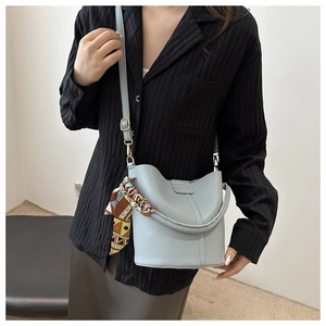 Detail der hellblauen Beuteltasche mit geometrischem Seidentuch und Kiesel-Leder