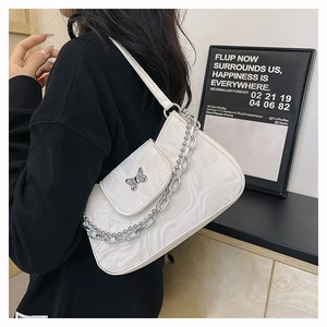 Détail du sac crème effet marbre avec boucle papillon argentée et bandoulière chaîne