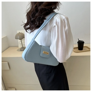 Detailansicht einer hellblauen baguette tasche mit elegantem goldfarbenem Verschluss