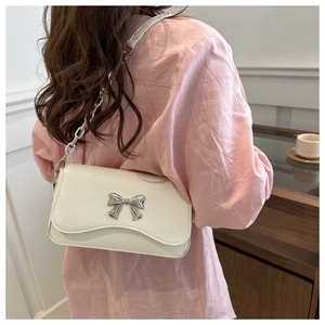Detailed view of white rectangular crossbody bag with silver butterfly buckle decoration