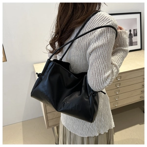 Dettaglio di una grande borsa tote nera in morbida pelle con logo CZHU e texture a pieghe
