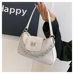 Gros plan du sac porté épaule crème avec motif marbre et boucle papillon argentée