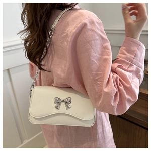 Detail of white PU leather bag with silver butterfly buckle and chain strap