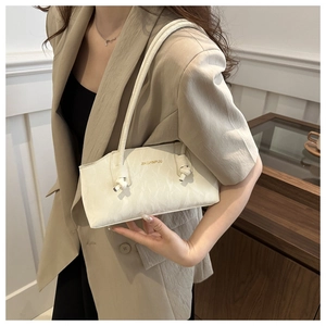 Détail du sac à bandoulière blanc texture marbre avec nœud décoratif et logo doré élégant